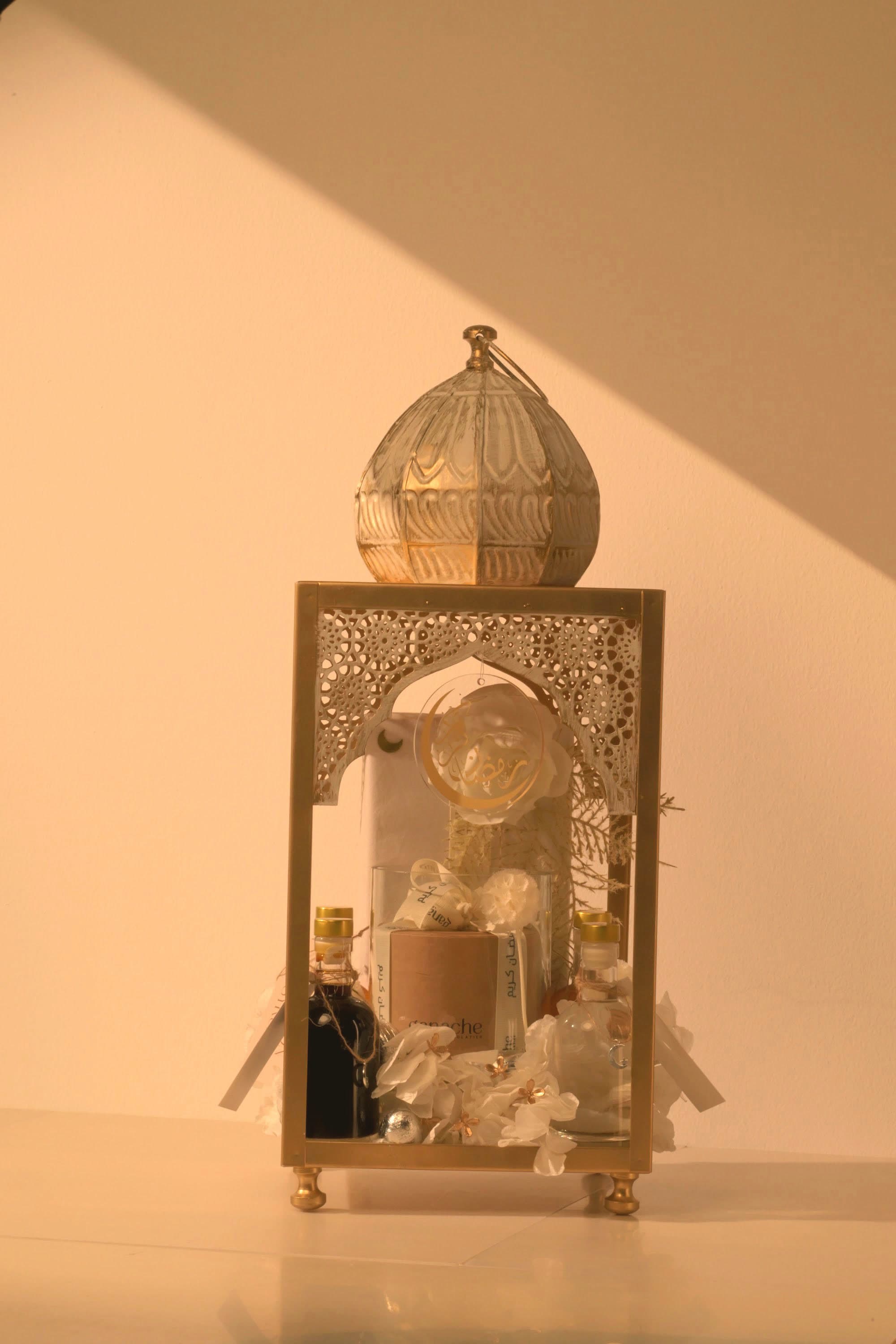 A bespoke Bare & Brown gift — a domed gold lantern arrangement with saffron, florals and chocolates, in warm natural light